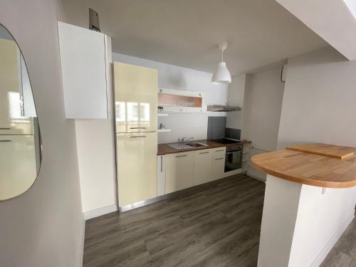 a kitchen with white cabinets and a wooden counter at Appartement T2 Centre Ville C1 in Châteauroux