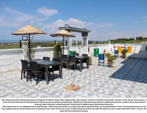 a patio with a table and chairs and umbrellas at Mavi Restaurant & Apartments 3 in Didim