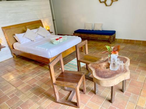 a bedroom with a bed and a table and chairs at Bird Island Bungalows in Bocas del Toro
