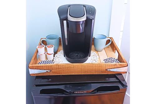 a coffee maker on a wooden tray on a stove at The Grand Castalian Inn Bed and Breakfast in Berkeley Springs