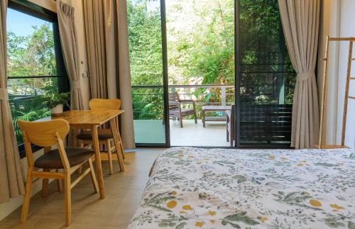 a bedroom with a bed and a table and chairs at Modern Bungalows in Ko Chang