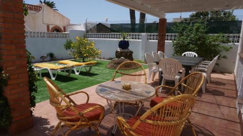 a patio with a table and chairs on a deck at Casa Jamila in El Alquián