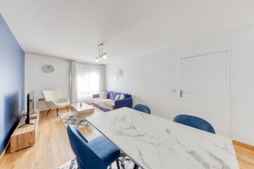 un salon avec une grande table en marbre et des chaises bleues dans l'établissement Room Proche Paris & Bercy 2 - Cozy Houses, à Charenton-le-Pont
