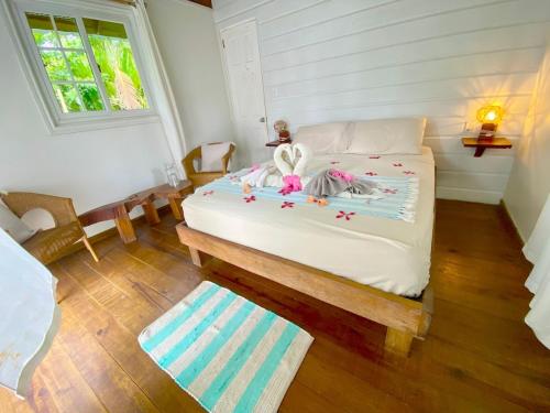 a bedroom with a bed with a doll sitting on it at Bird Island Bungalows in Bocas del Toro