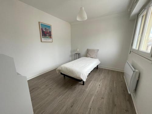 - une chambre blanche avec un lit dans l'établissement Appartement T4 Centre Ville C3, à Châteauroux
