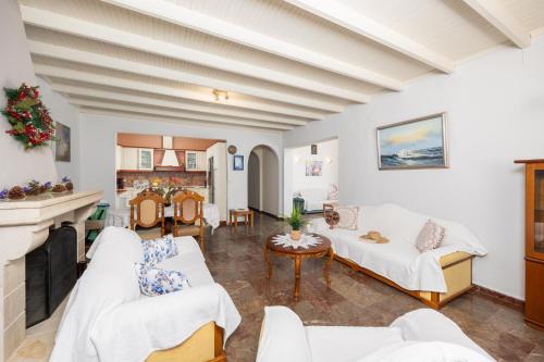 a living room with white furniture and a fireplace at Villa Theodora in Nisakion