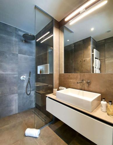 a bathroom with a sink and a shower at The Central City - Luxury Serviced Residence in Luxembourg