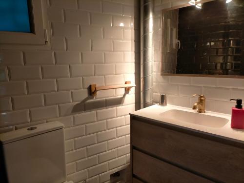 a white bathroom with a sink and a mirror at Apartamento rural con vistas in Miraflores de la Sierra