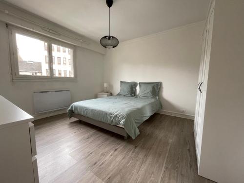 une chambre blanche avec un lit et une fenêtre dans l'établissement Appartement T4 Centre Ville C3, à Châteauroux