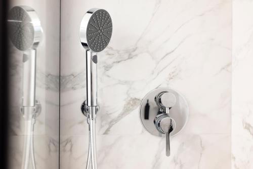 a shower with two shower heads on a marble wall at Visconti Suites - Luca Stay in Milan