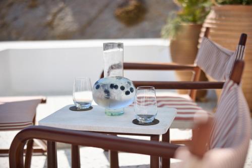 a table with two glasses and a vase on it at Nammos Hotel Mykonos in Psarou