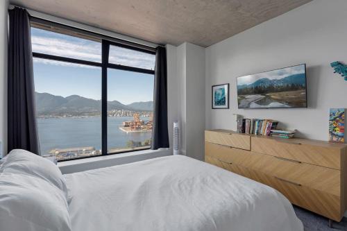 a bedroom with a large window with a view of the water at The W, Modernized 2 bedroom Downtown Highrise in Vancouver