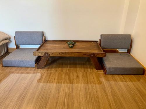 a wooden table with two chairs and a table with at Taka Onzen in Ban Khao Ket