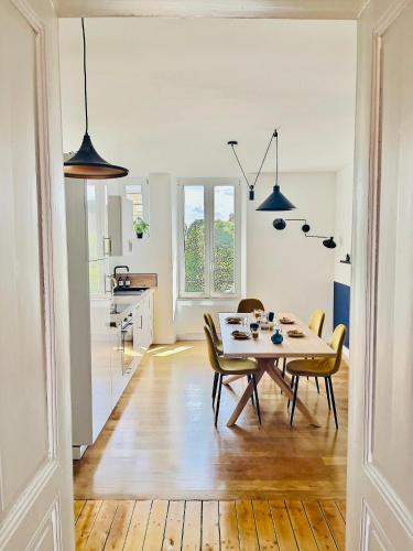 une cuisine et une salle à manger avec une table et des chaises dans l'établissement 201 - Appartement confortable face à la Maison du Peuple, à Belfort