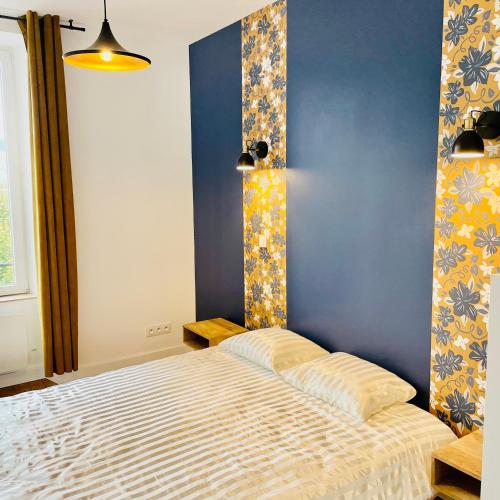 une chambre avec un lit et un mur bleu dans l'établissement 201 - Appartement confortable face à la Maison du Peuple, à Belfort