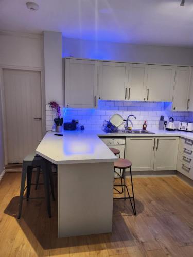 a kitchen with white cabinets and a blue ceiling at Beautiful stylish house near town centre in Rugby