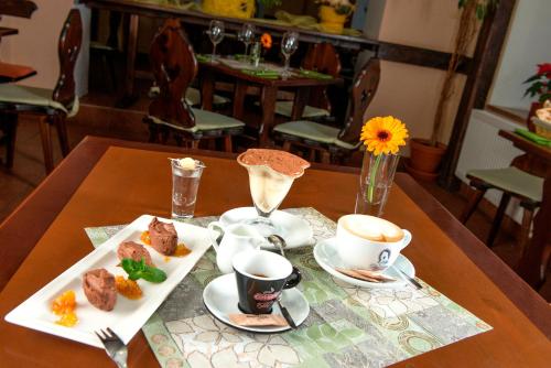 a table with two plates of food and cups of coffee at Pension Půlměsíc in Jablonec nad Nisou