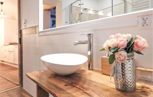 a bathroom with a sink and a vase of pink roses at Awesome Apartment In Nowe Warpno in Nowe Warpno