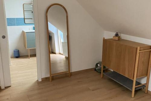 a hallway with a mirror and a dresser in a room at La Grangerie - Maison en pierre centre village in Arbonne-la-Foret