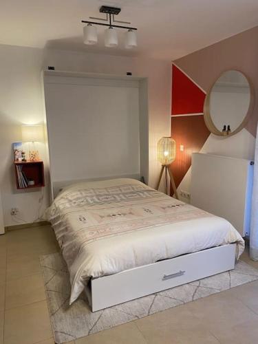 une chambre avec un grand lit et un miroir dans l'établissement Studio proche du lac Léman et de Genève, à Douvaine