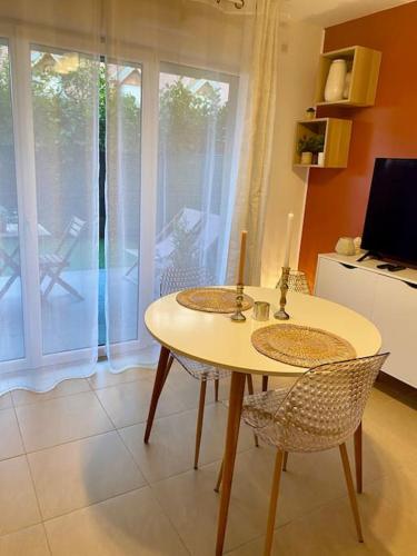 une cuisine avec une table et deux chaises et une cuisine avec un balcon dans l'établissement Studio proche du lac Léman et de Genève, à Douvaine