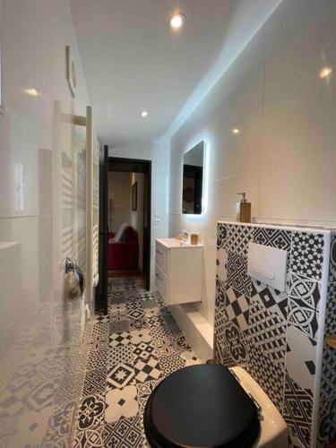 La salle de bains est pourvue de carrelage noir et blanc. dans l'établissement Studio Confortable - Périgueux, à Périgueux