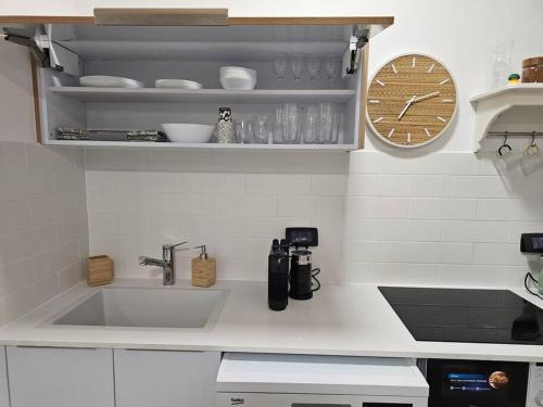 a kitchen with a sink and a clock on the wall at דירה אירוח בוכמן מודיעין CONDO Buchman Modi'in in Modi'in