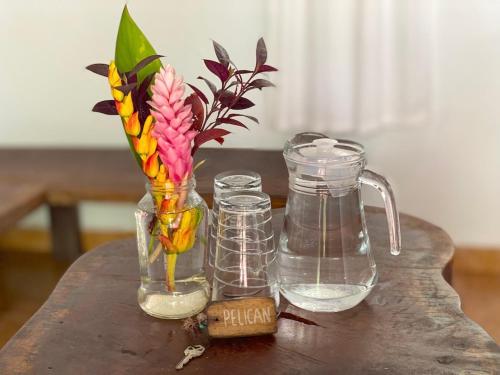 a table with two glass jars and a flower in a vase at Bird Island Bungalows in Bocas del Toro