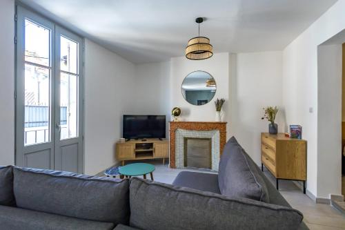 un salon avec un canapé et une cheminée dans l'établissement Appartement Sureau - Welkeys, à Avignon