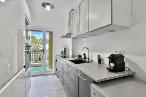 une cuisine avec un évier et un plan de travail dans l'établissement Le Sun Valley - Vidéoprojecteur et Terrasse Zen, à Cannes