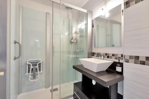 une salle de bain avec un lavabo et une douche en verre dans l'établissement Le Sun Valley - Vidéoprojecteur et Terrasse Zen, à Cannes