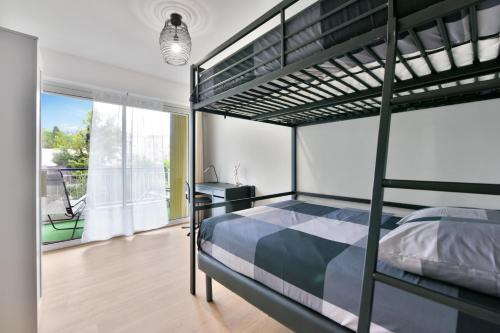 une chambre avec un lit superposé et un bureau dans l'établissement Le Sun Valley - Vidéoprojecteur et Terrasse Zen, à Cannes