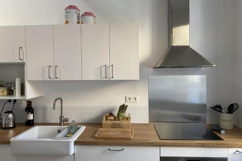 une cuisine avec des armoires blanches et un évier dans l'établissement Spacious house in Gruissan for 8 people, à Gruissan