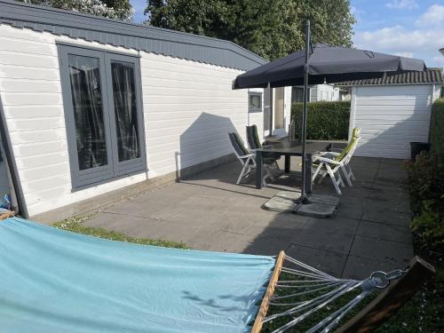 a patio with a table and an umbrella at NV 10 - Beach Resort Nieuwvliet Bad in Nieuwvliet
