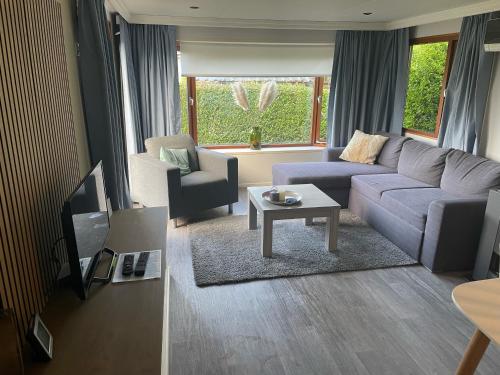 a living room with a couch and a tv at NV 10 - Beach Resort Nieuwvliet Bad in Nieuwvliet