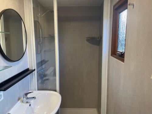 a bathroom with a sink and a mirror and a shower at NV 10 - Beach Resort Nieuwvliet Bad in Nieuwvliet