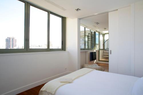 バルセロナにあるPG3 - Ático en Paseo de Graciaのベッドルーム(白いベッド1台、大きな窓付)