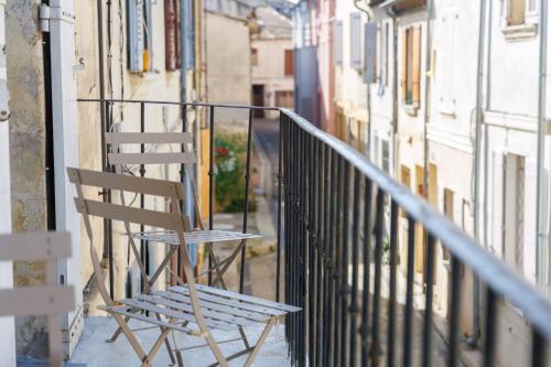 - une chaise en bois assise sur le côté du balcon dans l'établissement Appartement Sureau - Welkeys, à Avignon