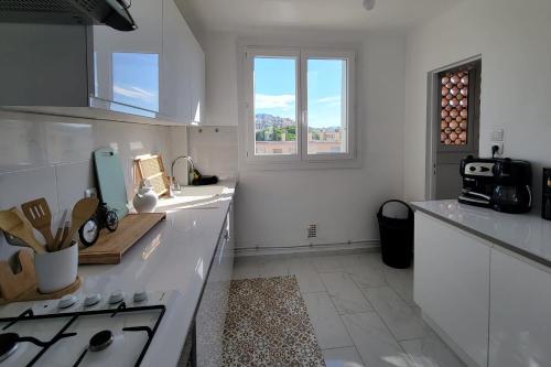 une cuisine blanche avec un évier et une fenêtre dans l'établissement Bright flat in Saint-Raphaël, à Saint-Raphaël