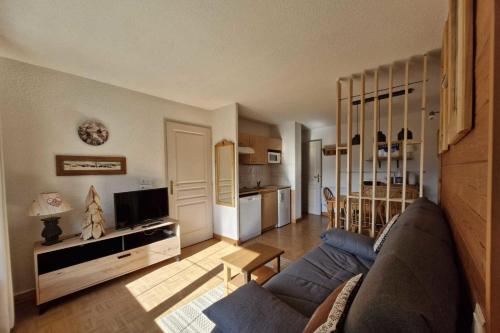 un salon avec un canapé et une cuisine dans l'établissement Cosy apartment with balcony and mountain view, à Flumet