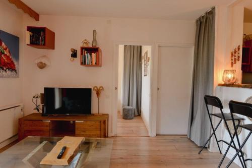 un salon avec une télévision sur une table en bois dans l'établissement Modern apartment in the Alps, à Les Deux Alpes