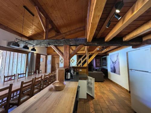 Cette grande chambre dispose d'une table et de chaises en bois. dans l'établissement Apartment Arolles, à Les Coches