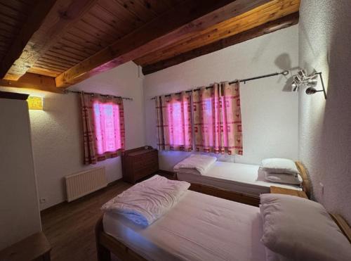 une chambre avec deux lits et deux fenêtres dans l'établissement Apartment Arolles, à Les Coches