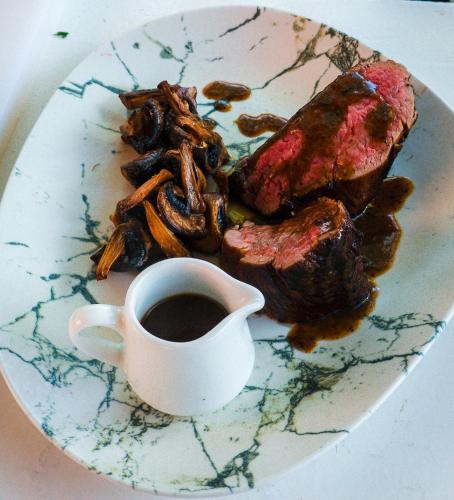 a plate of food with meat and a cup of coffee at Grand Mogador Menara & Spa in Marrakech