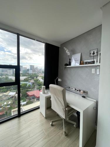 a white desk and chair in a room with a window at Premier Suites- Panoramic View in Cebu City