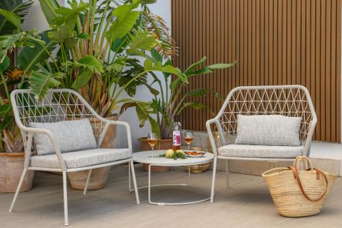 two chairs and a table in a room with plants at Hotel Marina in Port de Soller