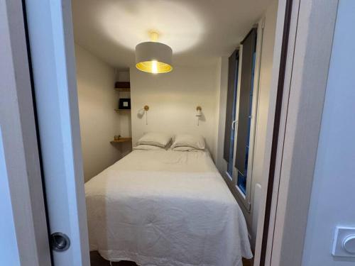 - une petite chambre avec un lit blanc dans l'établissement Beau 2 pièces central, à Paris