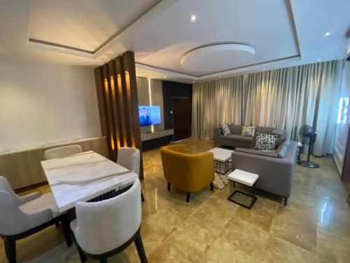 a living room with a couch and a table and chairs at Tobas Apartments in Uyo