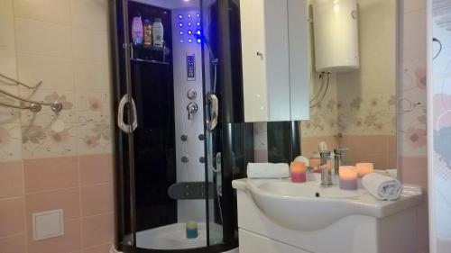 a bathroom with a sink and a shower with candles at Apartments Jasminka in Solin