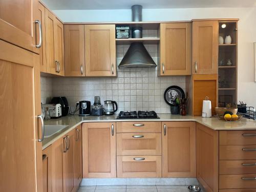 a kitchen with wooden cabinets and a stove at A cozy room economy class in the central thriving area next to Shiba & Bar Ilan in Ramat Gan